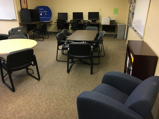 Shows chairs, a white board and a round table