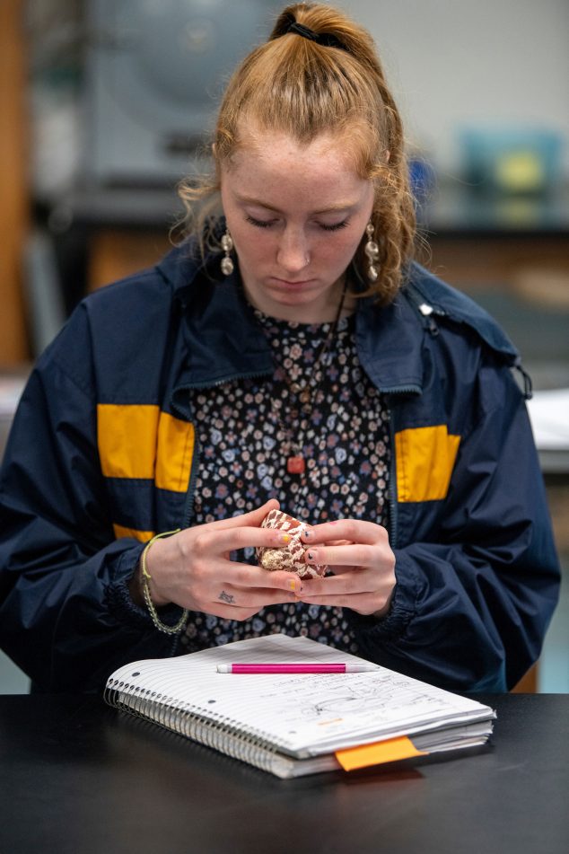 A student holding a seashell