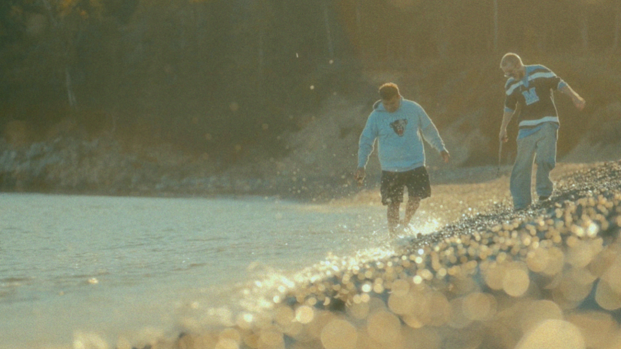 Two students walk along a rocky beach