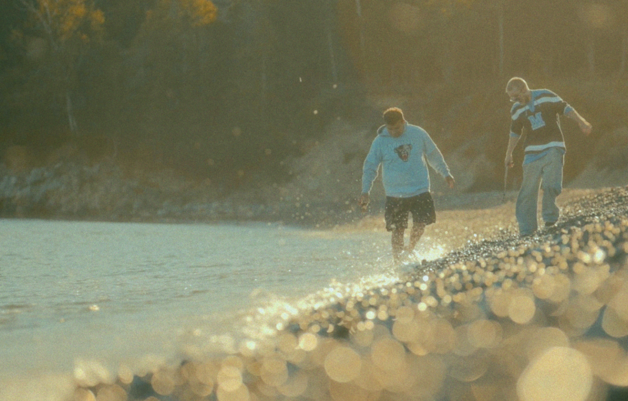 Two students walk along a rocky beach