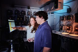 Student and staff member looking at data on a computer screen at the Downeast Institute