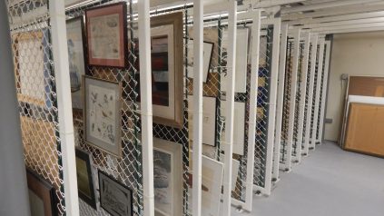 A photo of artwork on racks in a room