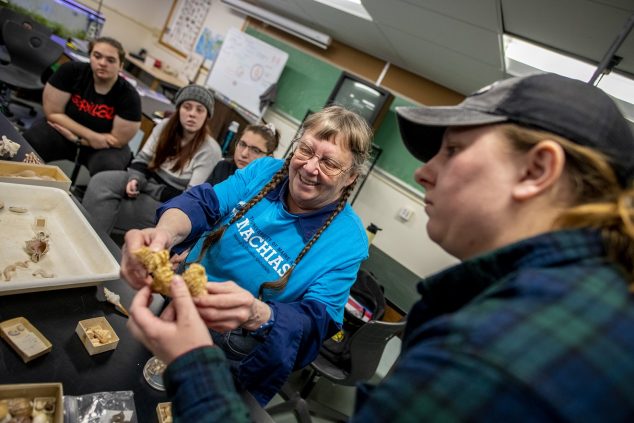 Students handling shells in a biology class