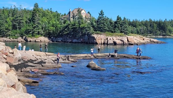 Students walk on the rock bank that sticks out of the ocean at the Downeast Institute on Beals Island. 