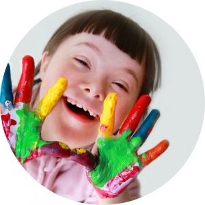 smiling student with colored paint on hands. Link to Supporting Diverse Learners pathway.