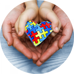 adult hands cradling child hands that are holding a heart with a puzzle pattern. Link to Inclusive Early Childhood Education pathway.