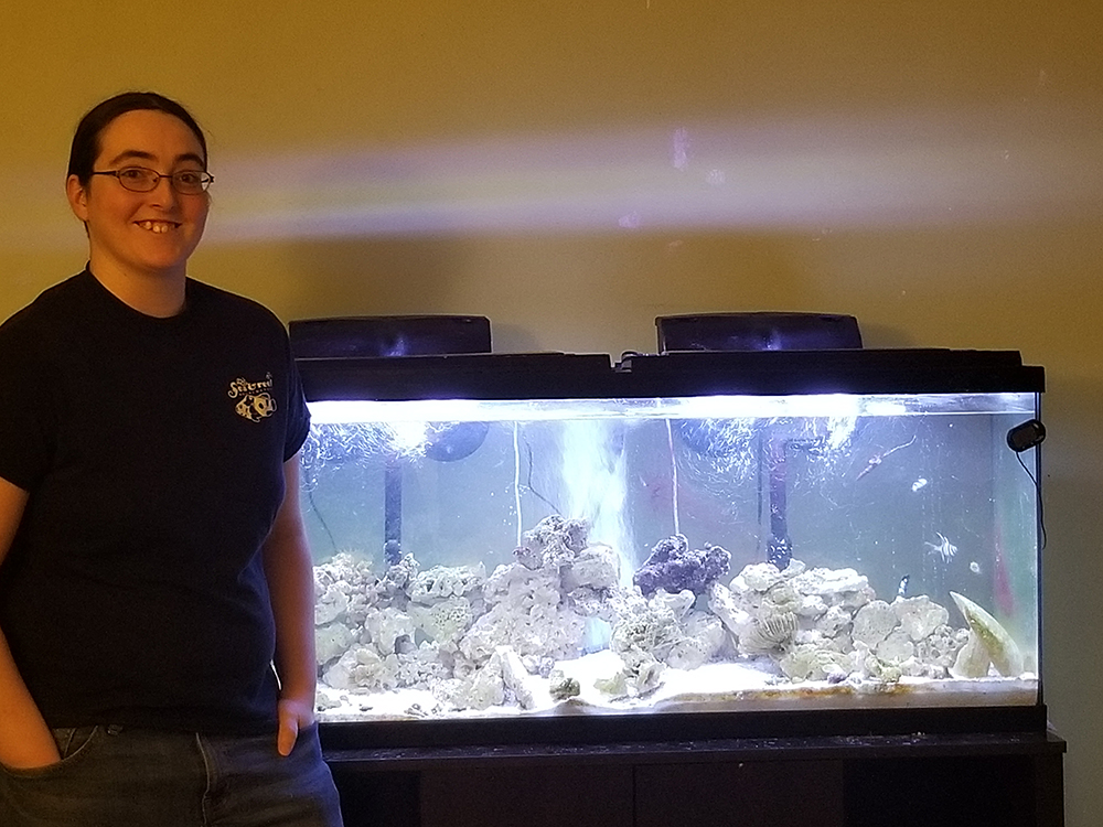 Aisling Farragher-Gemma poses next to a fish tank