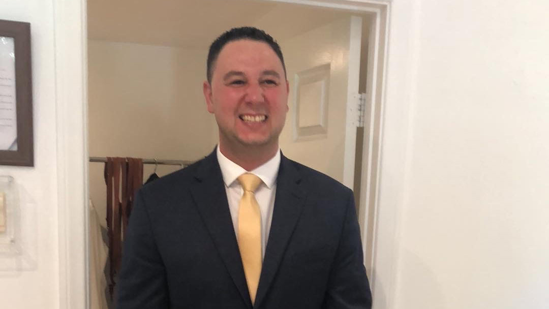 A smiling man wearing a business suit