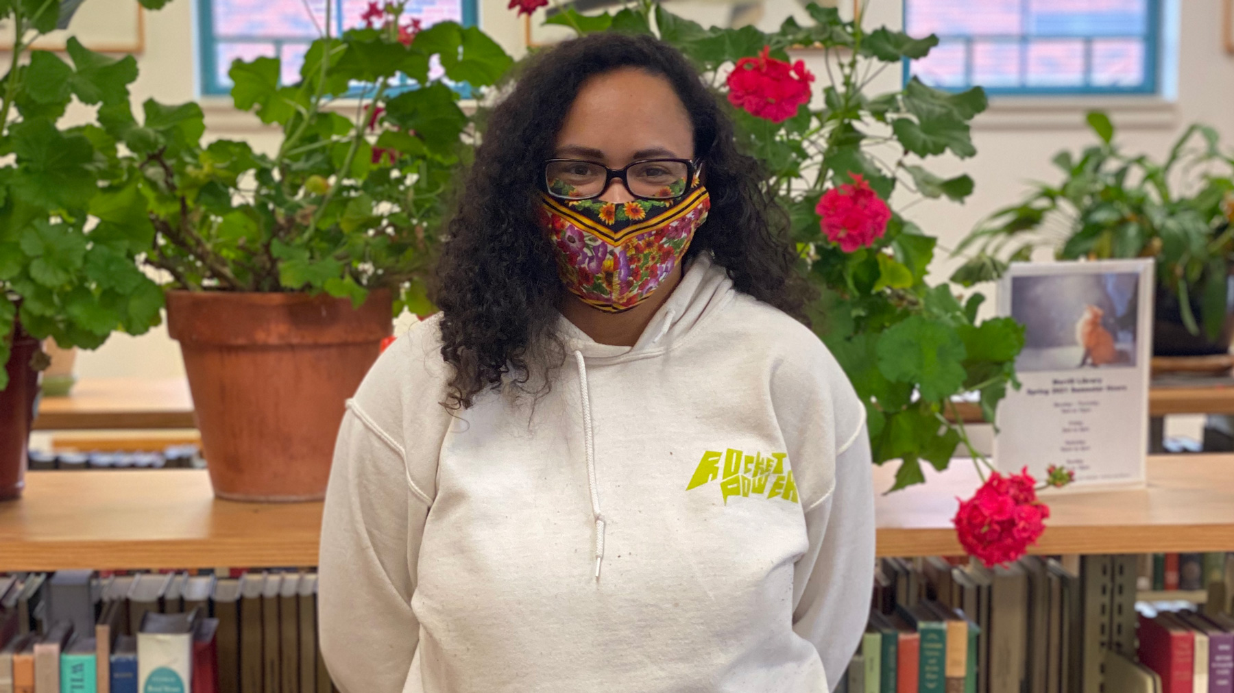 Aiyla Petty posing in front of bookshelves in the library