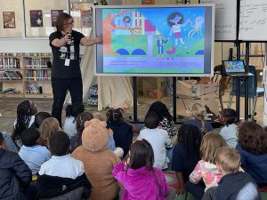Meghan shares a digital version of her book on a large TV while visiting an elementary class in Washington ,D.C. 