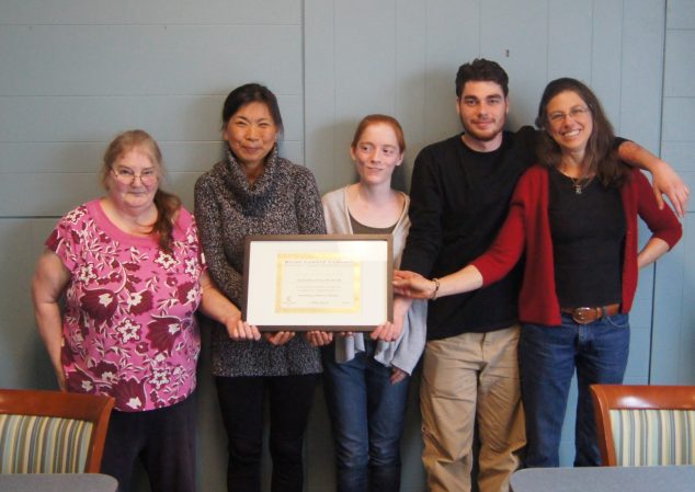 Five people holding a framed certificate