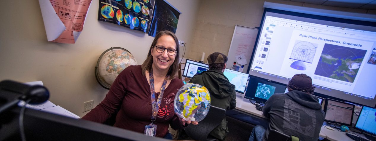 Photo of Tora Johnson holing an inflatable Glob in the GIS Center