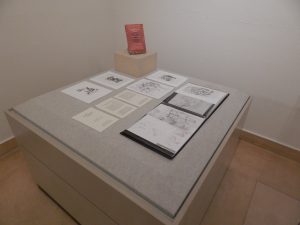 books and sketches displayed on a square gray table